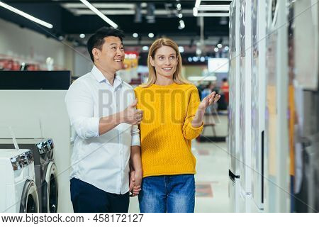 Happy Asian Couple Family Man And Woman Make A Choice Choose Of New Household Home Appliances In Sup