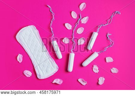 Female Tampons With With Cherry Petals And Woman Gasket On A Pink Background. Hygienic White Tampon 