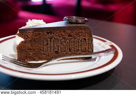 Piece Of Famous Sachertorte Chocolate Cake With Apricot Jam Of Austrian Origin Served With Whipped C