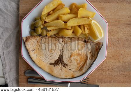 Seafood Dish, Grilled Steak From Swordfish Or Spada Served With French Fried Potatoes And Green Oliv