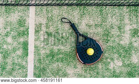 Yellow Ball On Top Of The Padel Racket And Behind Net On Green Court Grass Turf