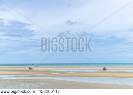 Fishing Boats Moored On A Sandy Beach At Low Tide. And The View Of The Sky Near The Rain Beautiful N