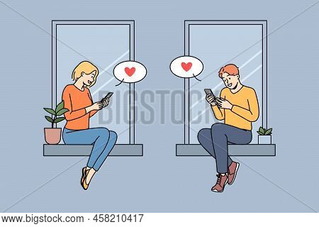 Couple Sitting On Windowsills Texting Online On Cellphones. Man And Woman In Love Message On Interne