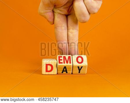 Demo Day Symbol. Concept Words Demo Day On Wooden Cubes. Businessman Hand. Beautiful Orange Table Or