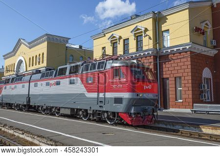 Oryol, Russia - July 06, 2021: Czech Passenger Electric Locomotive Chs7-015 Against The Background O
