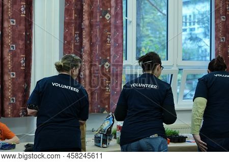 Volunteers At Work Preparing Something Together As One