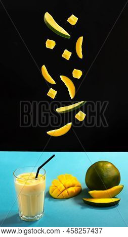 Milk Drink On Black Background With Mango. A Classic Mango Milkshake - Lassi. A Traditional Drink In