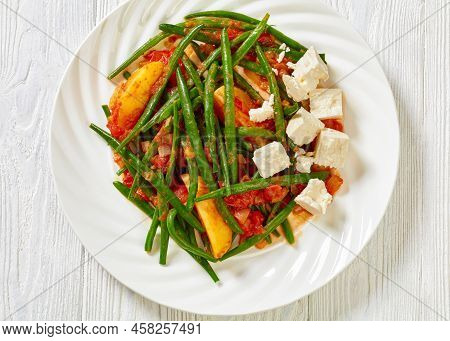 Fasolakia Lathera, Green Beans, Onion And Potatoes Stewed In Tomato, Herbs And Olive Oil On White Pl