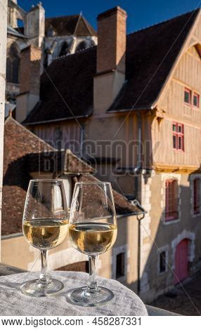 Tasting Of White Grand Cru Classe Chablis Wine With Old French Houses On Background, Burgundy, Franc