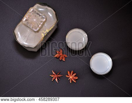 Anise Liqueur In A Bottle And Two Glasses On A Black Background, Dried Star Anise Fruits Nearby.