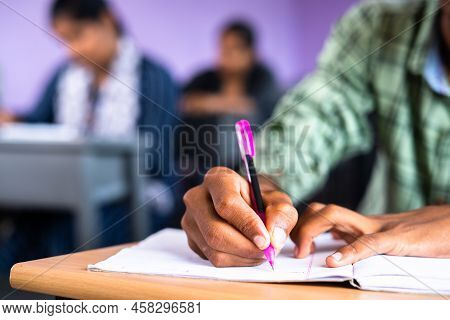 Close Up Shot Of College Student Writing Notes On Book At Classroom - Concept Of Examination, Develo