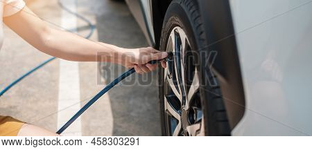 Hand Inflating Tires Of Vehicle, Checking Air Pressure And Filling Air On Car Wheel At Gas Station. 