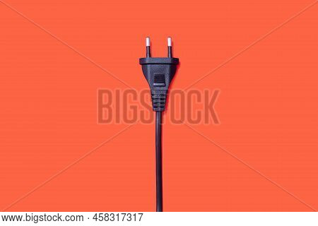 Electric Plug For An Outlet On An Orange Background. The Concept Of Electricity And Its Importance I