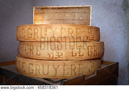 July 11 2022, Lyon, France : Stack Of Wheels Of Swiss Le Gruyère Pdo Cheese In A Cellar With A Honey