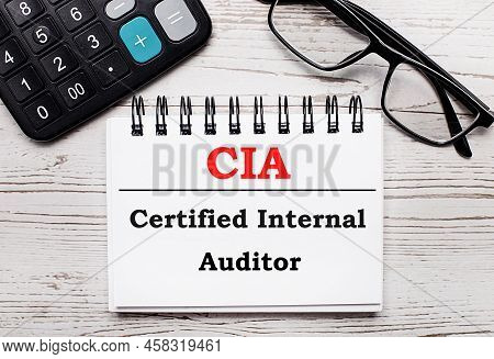 On A Light Wooden Table Calculator, Glasses And A Blank Notepad With The Text Cia Certified Internal