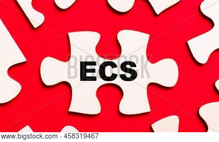 On A Bright Red Background, White Puzzles. In One Of The Pieces Of The Puzzle, The Text Ecs Electron