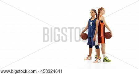 Portrait Of Two Young Girls, Basketball Players Posing With Basketball Ball Isolated On White Backgr