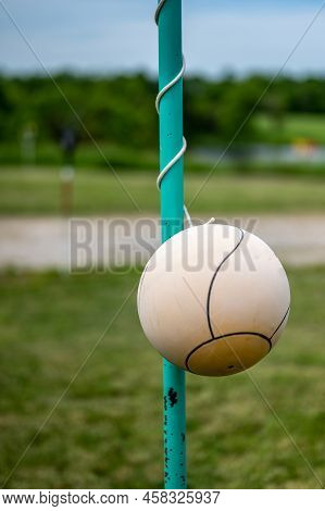 Tetherball Sitting Idle Next To The Pole In A Backyard.
