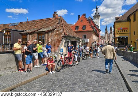 Würzburg, Germany - July 2022: Tourist Drinking Wine Sold By Local To Go At Famous Old Main Bridge