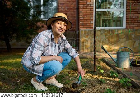 Beautiful Caucasian Woman, Farmer Agronomist Using Garden Shovel, Digging Soil And Making A Hole For