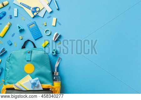 Back To School Concept. Top View Photo Of Open Blue Backpack With Plane Shaped Sharpener Sticky Note