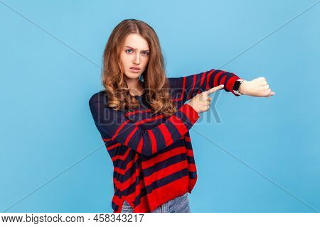 Time Is Gone. Young Serious Woman Wearing Striped Casual Style Sweater Showing Time On His Watch, Lo