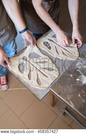 Bakers Shape And Cut Traditional French Fougasse Bread. Vertical Photo.