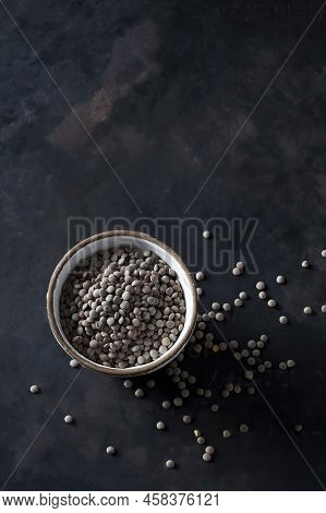 Pardina Lentils, Husk, Black Background. Vertical Photo