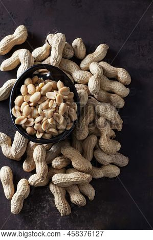 Bowl With Fresh Peanut And Peanuts In The Husk On The Table, Top View, Vertical Photo