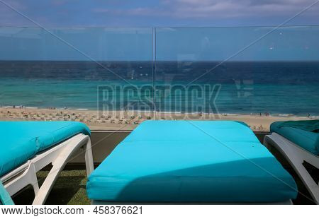 An Unoccupied Sun Lounger Overlooking The Beach.