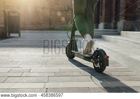 Woman In White Sneakers Is Standing On Electric Scooter