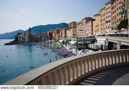 Camogli, Liguria, Italy - June, 2022: Beach With Umbrellas And Seafront With Typical Italian Houses.