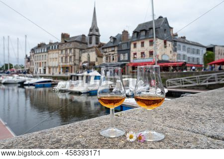 Tasting Of Apple Calvados Drink In Old Honfleur Harbour With Boats And Old Houses On Background, Nor
