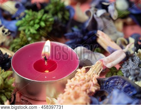 Burning Candle And Flower Confetti Or Potpourri. Candle Close-up.