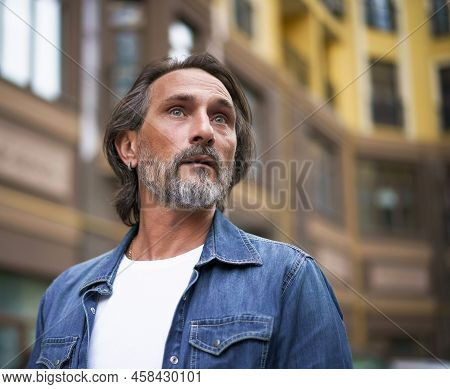 Interested, Alarmed Middle Aged Man Looking At Situation Got His Attention Walking In City. Man Stay