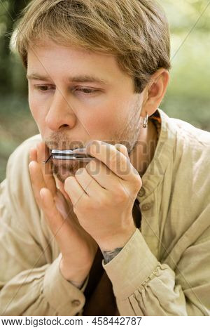 Portrait Of Man Playing Jews Harp In Forest
