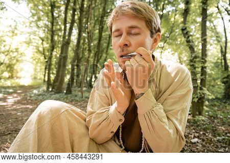 Young Man Playing Vargan In Blurred Forest