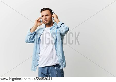 Young Serious Tanned Handsome Man In Casual Basic T-shirt Touch Wear Headphones Listen Fav Playlist 
