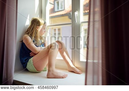 Beautiful Preteen Girl Looking Out The Window. Young Girl Sitting On A Windowsill.