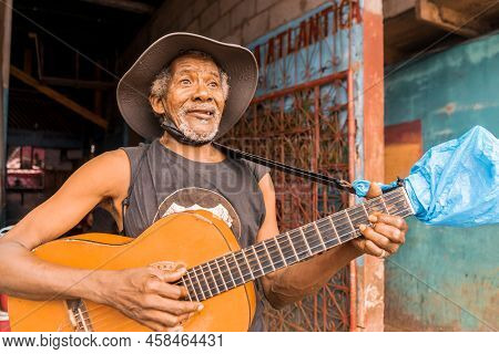 Native African American Singer From Bluefields Smiling And Playing Guitar And Singing