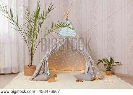 Cool Children's Wigwam In The Room On The Floor On White Soft Carpet With Flowers Near Peetee Tent.