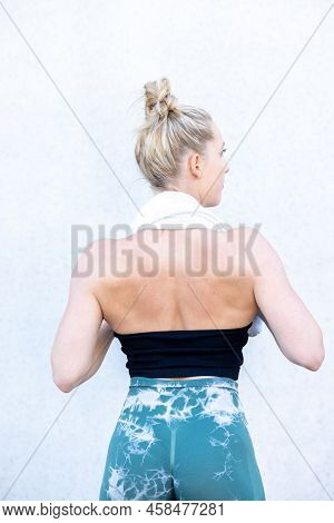Half Body Rear View Shot Of A Gym Fit Caucasian Sporty Woman Dressed In Sportswear And With Her Hair