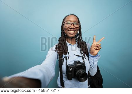 Excited Joyful Photography Entusiast Taking Selfie Photos While Standing On Blue Background. Happy S