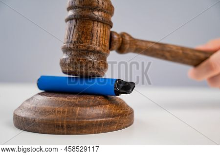 Judge Hammering Disposable Vape With Referees Gavel On White Table.
