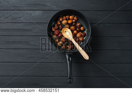 Pan Of Fried Mushrooms Champignons On A Dark Wooden Background. Top View. Place For Text And Copy Sp