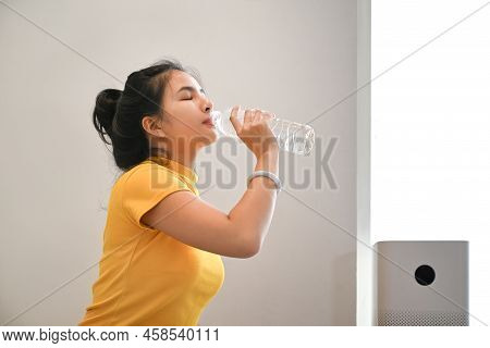 Healthy Young Woman In Sports Clothes Drinking Water And Resting After Morning Workout