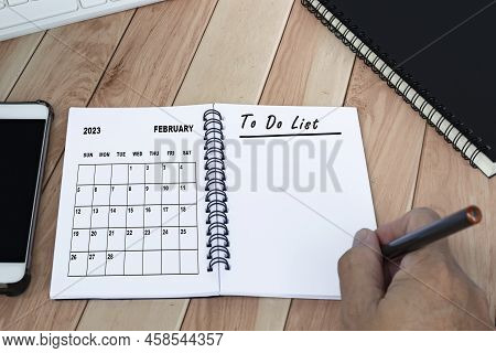 Businessman Hands With Pen Writing To Do List With Bebruary 2023 Calendar On Notebook. Copy Space. B