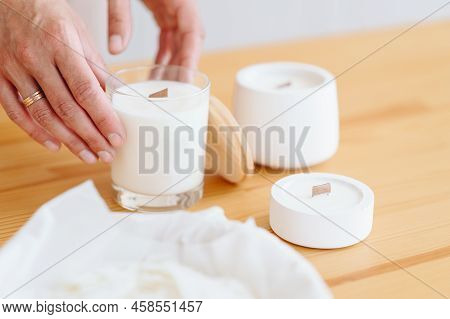Place Under Label On Soy White Candles. Group Of White Candles Stand On Wooden Table. Women's H\hand