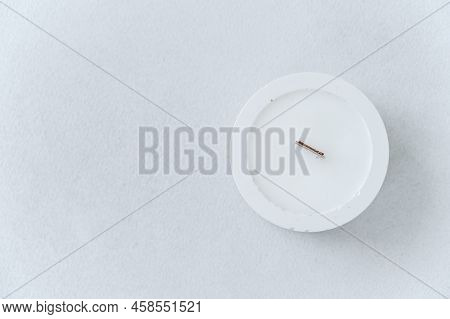 White Candle With Wooden Wick On Concrete Clean Background Top View. On Left Is Free Space For Text.