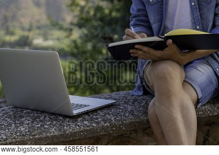 Unrecognizable Young Man Drawing On His Notebook About His Online Entrepeneur Project While Living A